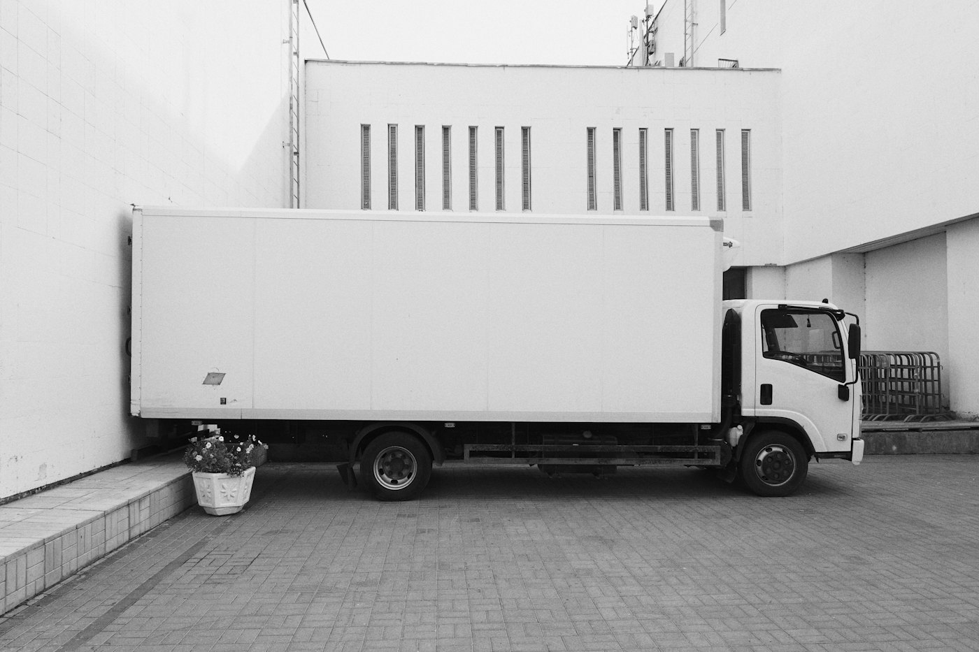 White box truck parked at a loading area