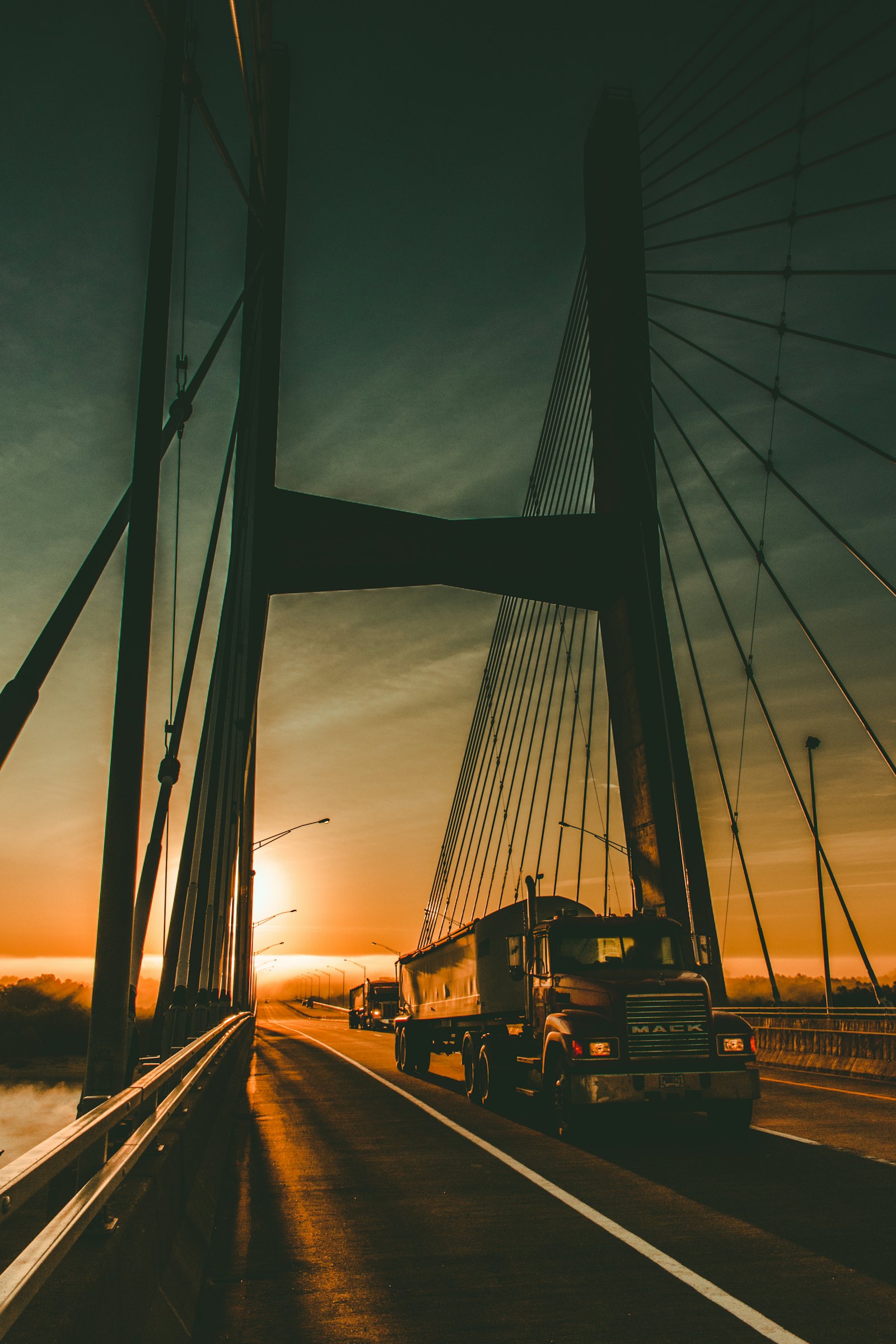 Truck crossing a cable-stayed bridge at dawn